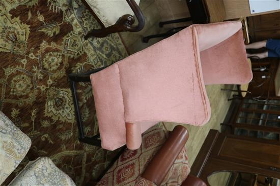 A George III mahogany framed pink dralon upholstered wing armchair